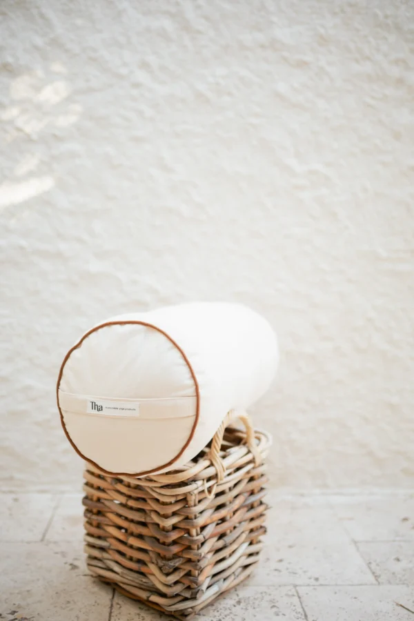 Kiremit tonunda keten–pamuk karışımı silindir yoga minderi, doğal dokusuyla detay çekimde görünüyor.