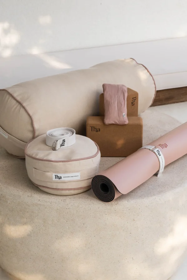 Pembe tonlarında yoga matı, bloklar, meditasyon minderi ve kemerden oluşan başlangıç seti