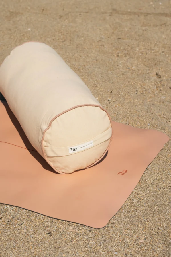 Pembe silindir yoga minderinin fermuarlı kılıfı ve aynı kumaştan taşıma kemeri.